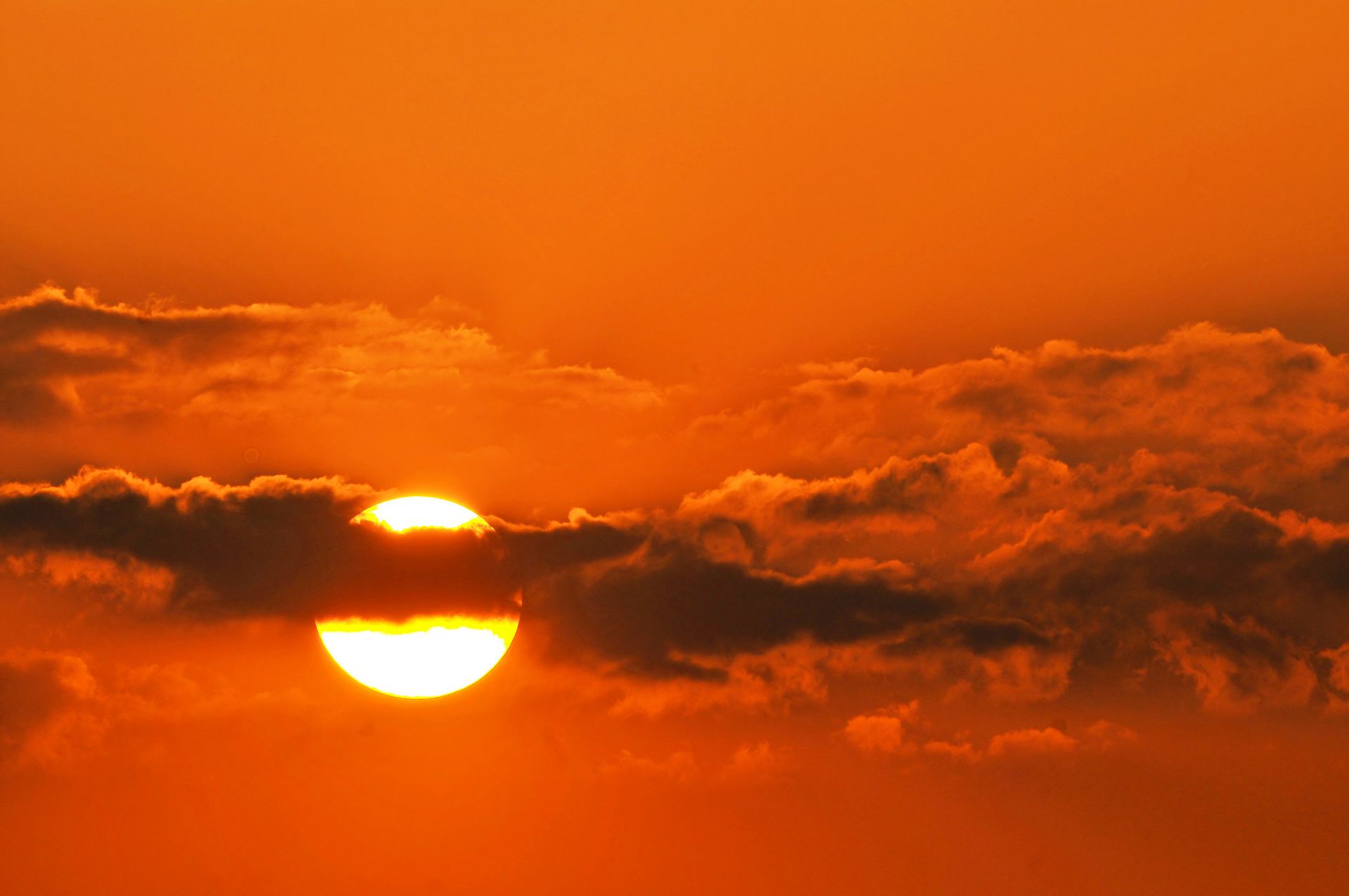 Photo | Sun behind a streak of clouds at sunset | UCLA